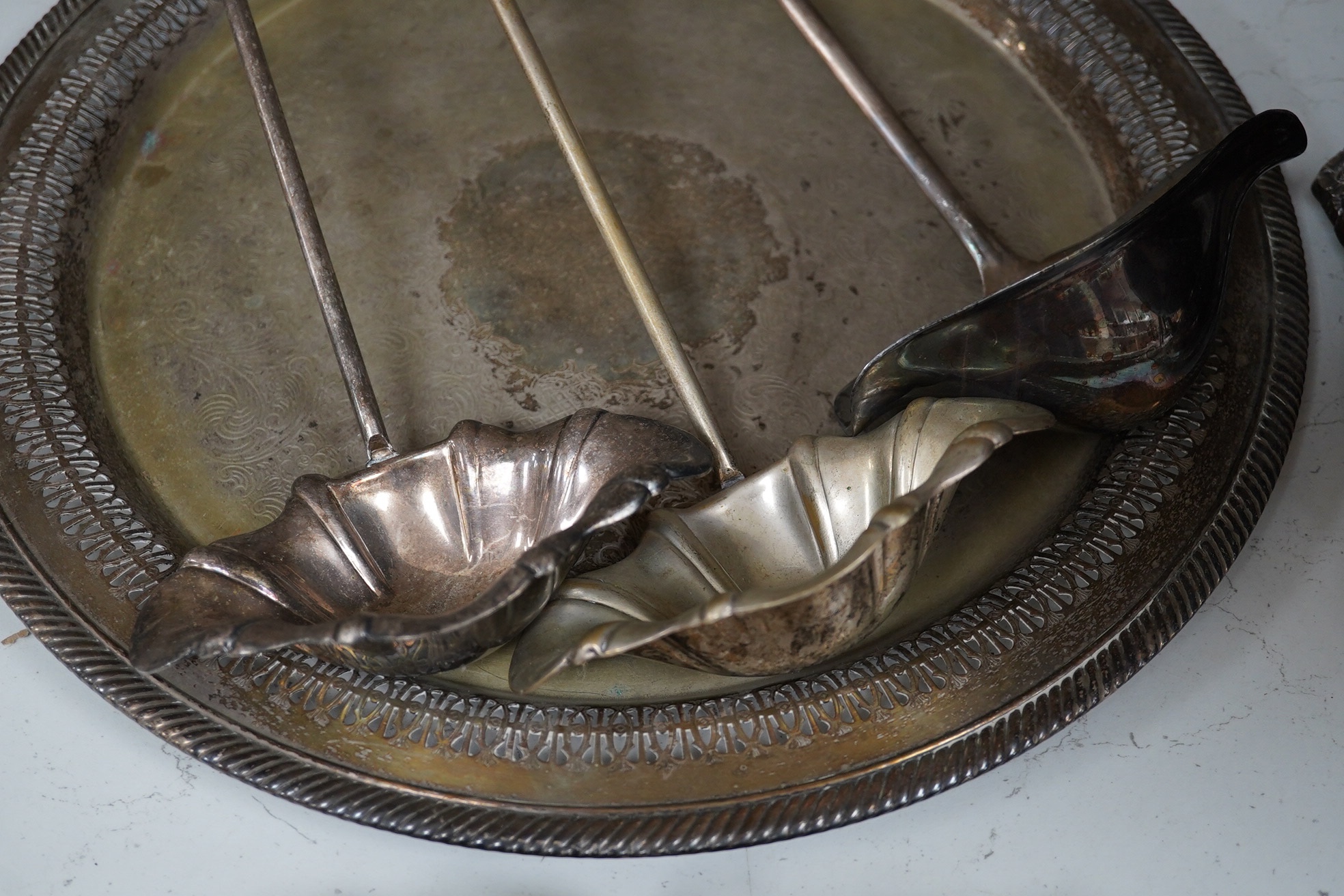 A collection of silver plate comprising large punchbowl, three plated ladles and three plated trays, punchbowl 43cm diameter. Condition - fair, worn